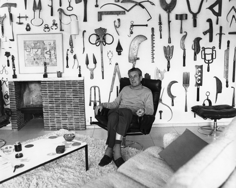 Louis Van Lint in his living room. Part of his tools collection covers the wall in the background.